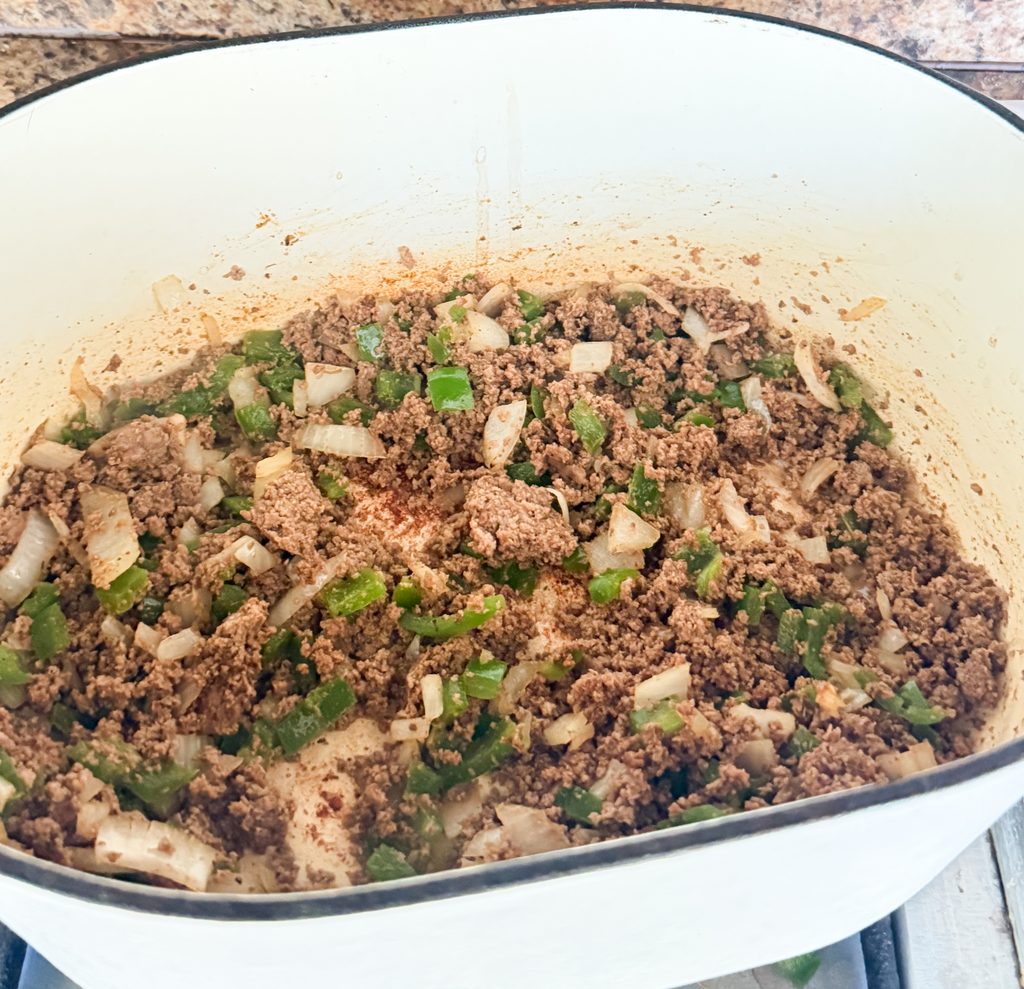 Ground turkey browning with diced onions, bell pepper, and jalapeño in a Dutch oven.