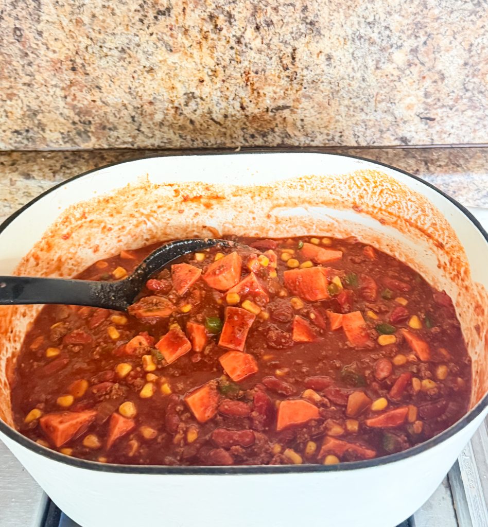 Hearty sweet potato turkey chili ready to serve in a Dutch oven.